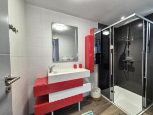 un bagno con un lavandino rosso e una doccia di Apartment in Erquy near Scenic Beaches a Erquy
