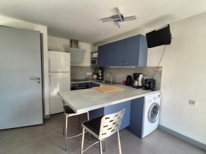 una cucina con armadi blu e frigorifero bianco di Apartment in Erquy near Scenic Beaches a Erquy