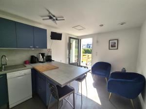 una cucina con bancone e due sedie blu di Apartment in Erquy near Scenic Beaches a Erquy Altre 8 foto