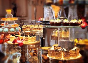 a display case with many different types of cakes and pastries at Dalat Palace Heritage Hotel in Da Lat