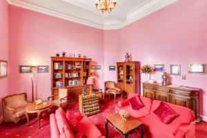 a living room with pink walls and a red couch at Dalat Palace Heritage Hotel in Da Lat