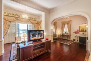 a living room with a flat screen tv in a room at Dalat Palace Heritage Hotel in Da Lat