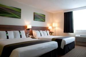 Habitación de hotel con 2 camas y ventana en Holiday Inn Slough Windsor, an IHG Hotel en Slough