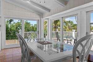 comedor con mesa y sillas en el porche en Gramma Dot's Marina House, en Sanibel
