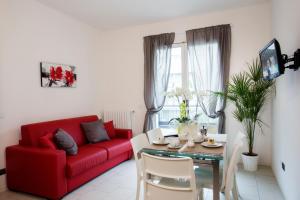 a living room with a red couch and a table at Residence Altea in Riccione