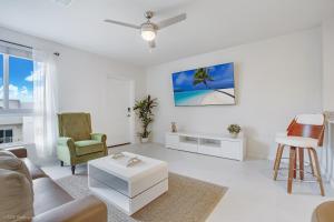 Una sala de estar blanca con un sofá y una mesa. en Beachside Bliss, 1BR Condo with Pool at Dania Beach, en Dania Beach