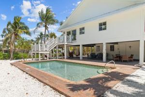 una casa con piscina delante de una casa en Gramma Dot's Marina House, en Sanibel