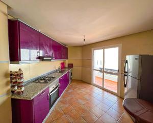 a kitchen with purple cabinets and a refrigerator at Visit Chamal - Solaya in Oued Laou