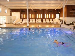 a group of people swimming in a large swimming pool at Les Folies d 'Oscar in Châtellerault