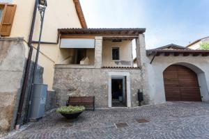 a building with a gate and a bench in front of it at Casa Di Laura in Roe