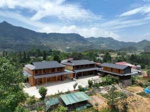 an aerial view of a house with mountains in the background at LÝ GIA HOMESTAY in Ha Giang