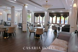 a hotel room with tables and chairs and windows at Casaria Hotel in La Phù