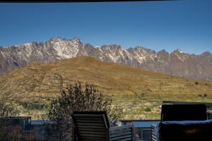 a view of a mountain range with chairs in the foreground at Remarkables View Eco House in Queenstown