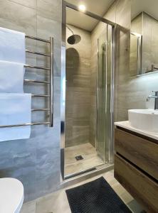 Un baño con ducha, inodoro y lavabo. en 2BR City Townhouse with air con Courtyard and Parking, en Auckland 14 fotos más