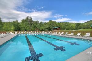 a swimming pool with chairs and a cross in the water at VIEWS! - Hot Tub - 3 Decks - Community Pool in Park Settlement