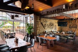 a restaurant with tables and chairs and a stone wall at Naracoorte Hotel Motel in Naracoorte