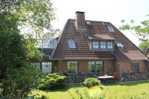 une maison avec un toit et une table dans la cour dans l'établissement Marschenblick-1, à Sankt Peter-Ording