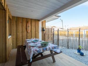 a table with bowls on it on a patio at Appartement T3 PMR Biscarrosse 6 Pers, Clim Parking - FR-1-319-607 in Biscarrosse