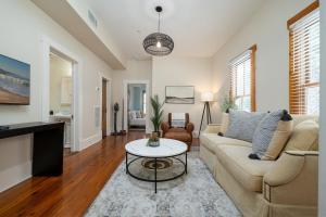 a living room with a couch and a table at Be A Nomad - Pool - 1bdr Just 1 Block to the Beach in Jacksonville Beach
