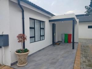 a white house with a patio with a plant at Three Bedroom House Spacious and Comfortable in Sandton
