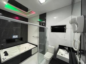 a bathroom with a shower and a toilet and a sink at Pousada Papito Ubatuba - Praia Perequê-Açu in Ubatuba