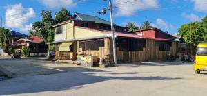 a yellow van parked in front of a building at Casetta Homestay Siargao in General Luna