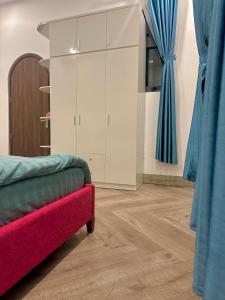 a living room with a red couch and blue curtains at Thalia Home Măng Đen in Kon Plong