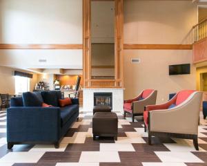a living room with couches and a fireplace at Comfort Suites Benton Harbor - St Joseph in Benton Harbor