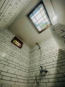 a bathroom with a shower and a window at Coffee Homestay Tetebatu in Tetebatu