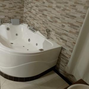 a white bath tub sitting in a bathroom at Hotel santa fe plaza sucursal HBP in Santa Fe de Antioquia