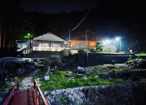 uma casa à noite com luzes no quintal em 時間を忘れる貸別荘オールブルー em Hiroshima