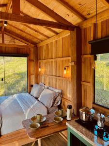 a bedroom with a bed in a wooden cabin at Cabana Serra do Vento in Passa Quatro