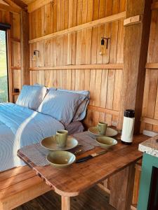 a wooden table with two cups and saucers on it at Cabana Serra do Vento in Passa Quatro