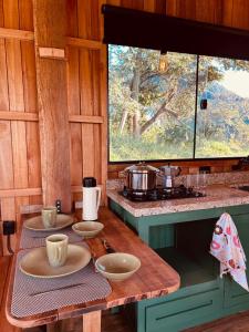 a kitchen with two plates on a wooden table at Cabana Serra do Vento in Passa Quatro +16 photos