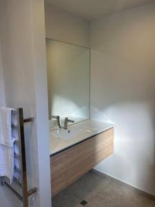 ein Badezimmer mit Waschbecken und Spiegel in der Unterkunft Heart of the City Stay - With the Best Coffee! in Christchurch