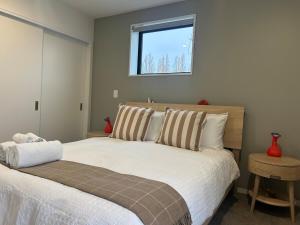 ein Schlafzimmer mit einem großen weißen Bett mit einem Fenster in der Unterkunft Heart of the City Stay - With the Best Coffee! in Christchurch