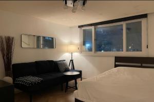 a bedroom with a couch and a bed and a window at Iee Sang House Room 3, 4 queen beds #COEX #Plastic surgery #Hospital #Lotte World #Free parking #Family #Friends in Seoul