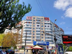 a tall building on a city street with people in front of it at Black and White apartment in Chişinău