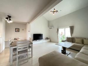 a living room with a couch and a table at 美ら海水族館まで車で5分 ジャングリアにも車で25分の好立地 Villa Clownfish Reef in Motobu