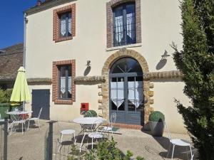 un bâtiment avec une table et des chaises devant lui dans l'établissement Gîte spacieux 200m² en ferme rénovée avec terrasse, à proximité de Montfort l'Amaury et Thoiry - FR-1-527-40, à Mareil-le-Guyon