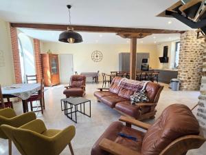Il comprend un salon avec des canapés et des chaises ainsi qu'une cuisine. dans l'établissement Gîte spacieux 200m² en ferme rénovée avec terrasse, à proximité de Montfort l'Amaury et Thoiry - FR-1-527-40, à Mareil-le-Guyon