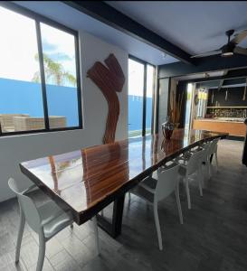 a dining room with a wooden table and chairs at Casa Gigante de lujo, con piscina privada, 4 amplias habitaciones con baño privado in Playa del Carmen +18 photos