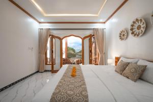 a bedroom with a large white bed and a window at Bali Chy Healing House in Dalung +40 photos