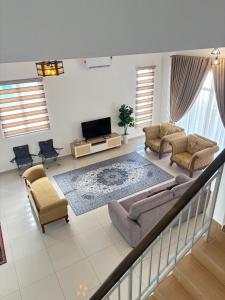 un salon avec un canapé et une télévision dans l'établissement Olive Homestay SP Saujana 5 Bedrooms 6 Toilets Mus lim Friendly, à Sungai Petani
