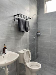 une salle de bain avec des toilettes blanches et un lavabo dans l'établissement Olive Homestay SP Saujana 5 Bedrooms 6 Toilets Mus lim Friendly, à Sungai Petani