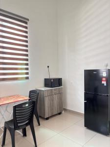 une cuisine avec un réfrigérateur noir, une table et des chaises dans l'établissement Olive Homestay SP Saujana 5 Bedrooms 6 Toilets Mus lim Friendly, à Sungai Petani 13 autres photos