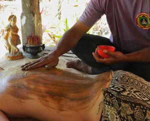 a man getting a tattoo on the back of a woman at Bali Chy Healing House in Dalung