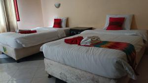 a hotel room with two beds with towels on them at edOTEL K-One Mandalika 002 in Praya