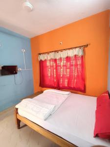 a bed in a room with a red window at Budget Friendly Rooms in Coorg in Jāmb