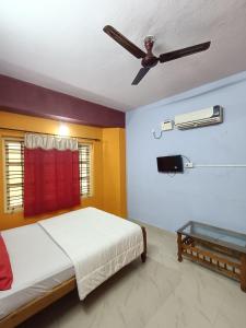 a bedroom with a bed and a ceiling fan at Budget Friendly Rooms in Coorg in Jāmb